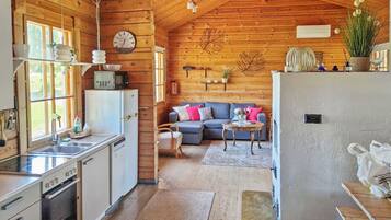 A cabin interior with a kitchen, dining area, and living room.