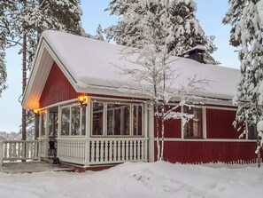 A snow-covered wooden house with a porch and a visible chimney. - Kaukosaaren ahonlaita by Interhome (Kuusamo)