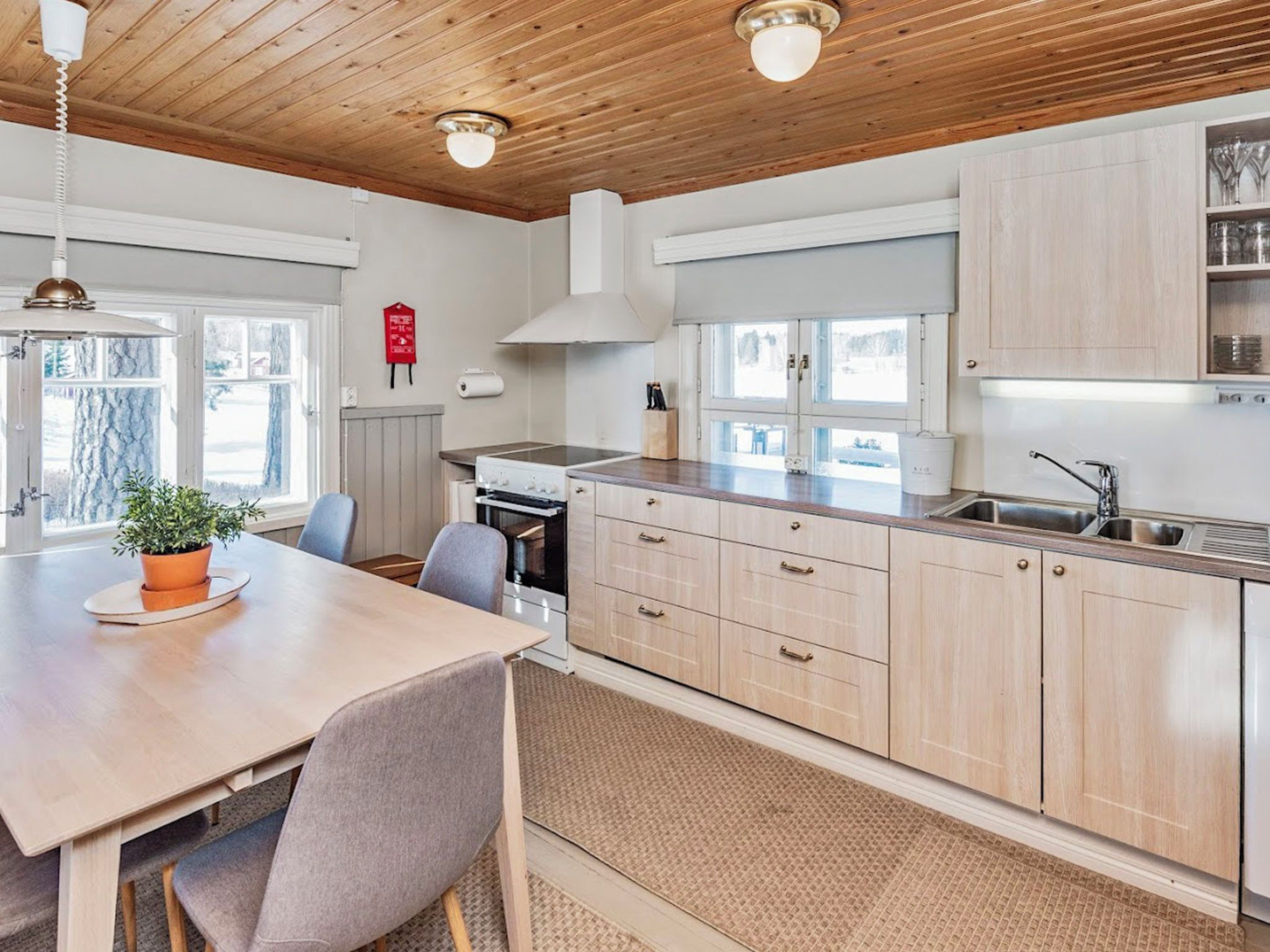 Une cuisine moderne avec des meubles en bois, un îlot central et un coin repas avec des chaises.