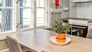 A modern kitchen with a wooden table, a potted plant, and a stove. - Punatulkku by Interhome (Somero)