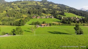 A rural landscape with a small village nestled among rolling hills and dense forests. - Sonnenfreude, Chalet by Interhome (Schönried)