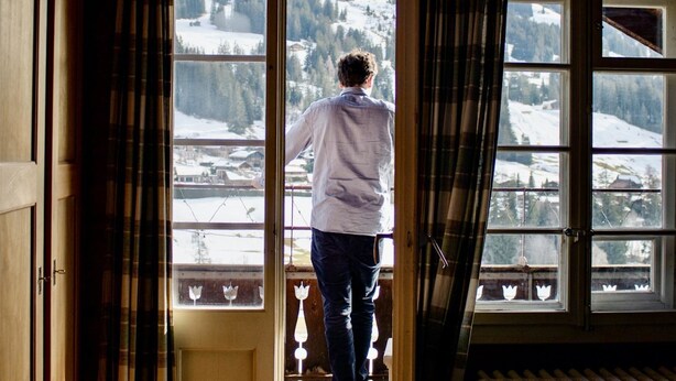 A person standing at a doorway with a view of a snowy mountain landscape. - Sonnenfreude, Chalet by Interhome (Schönried)