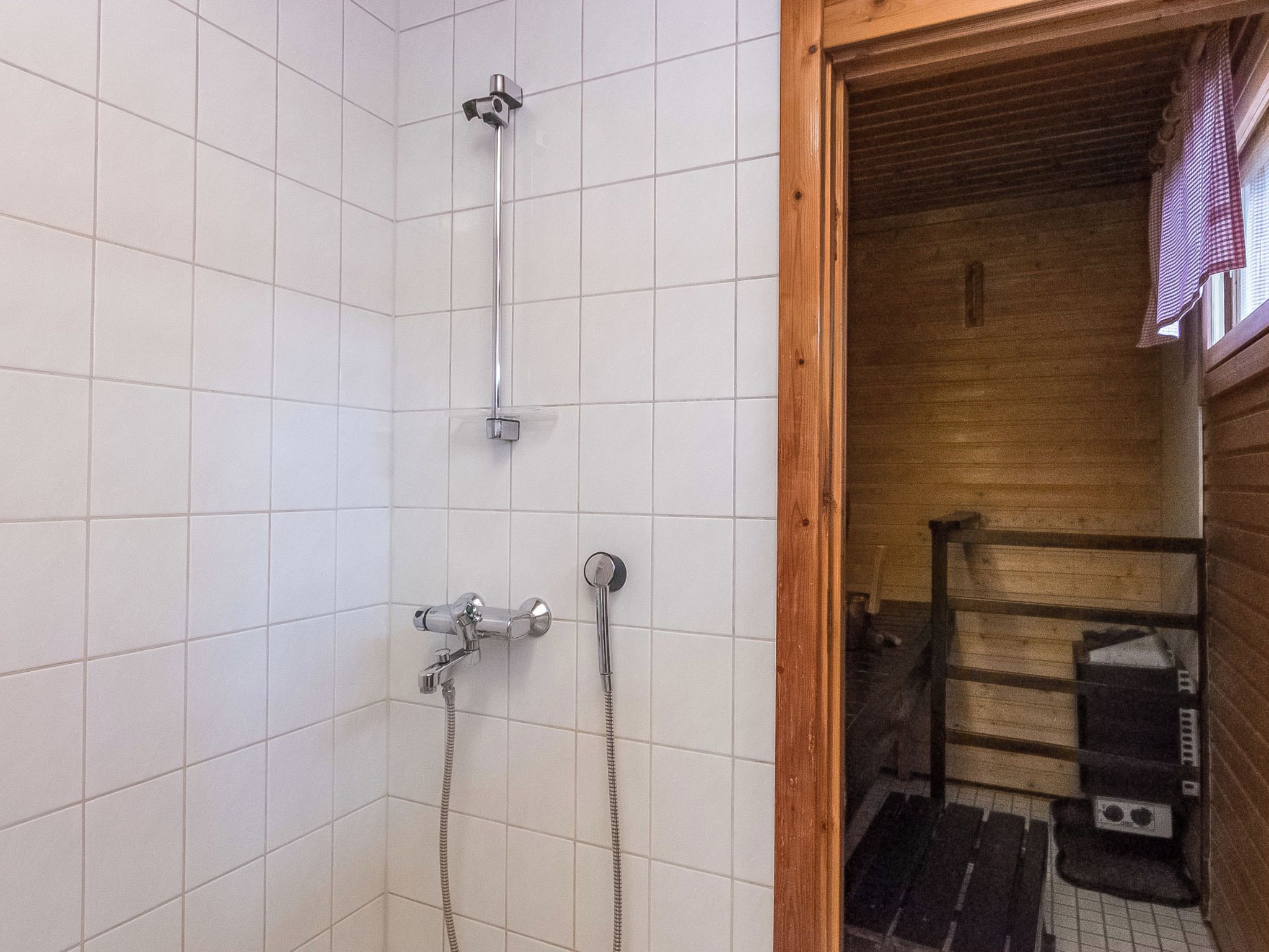 Suihkussa on käsisuihkupää ja seinään asennettu hana.