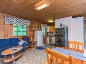A cozy cabin interior with a living area, a kitchen, and a dining space.