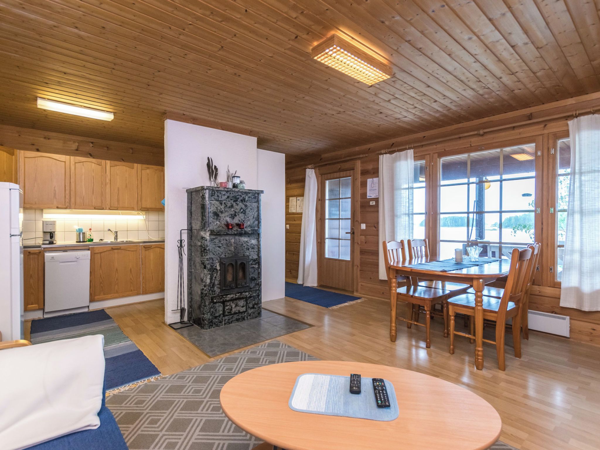 Un intérieur en bois comprenant une cuisine, un coin repas et une cheminée.