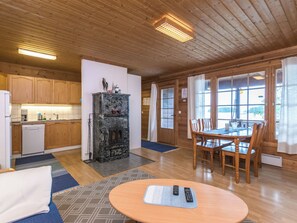 Un interior de madera con cocina, comedor y chimenea.