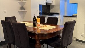 A dining area with a round table, six chairs, and a bottle of wine. - Mier Gfallt's by Interhome (Saas-Fee)