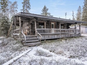 A log cabin with a porch and steps leading up to the entrance.