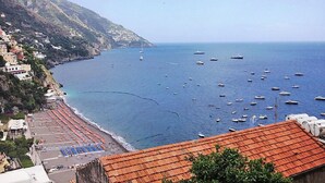 Eine Küstenstadt mit Strand, Booten und Häusern entlang der Klippe.