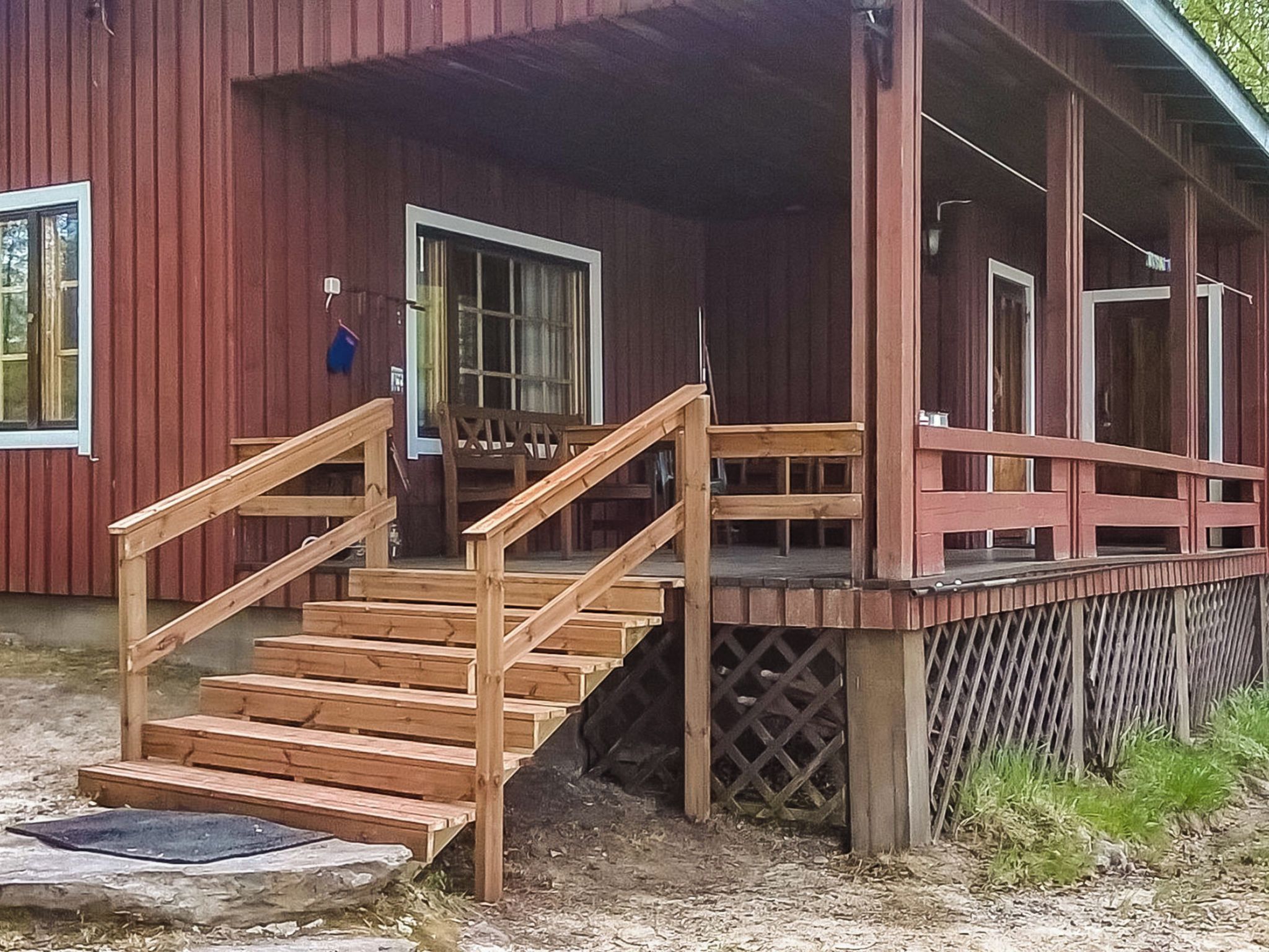 A wooden staircase leading to a porch with a railing.