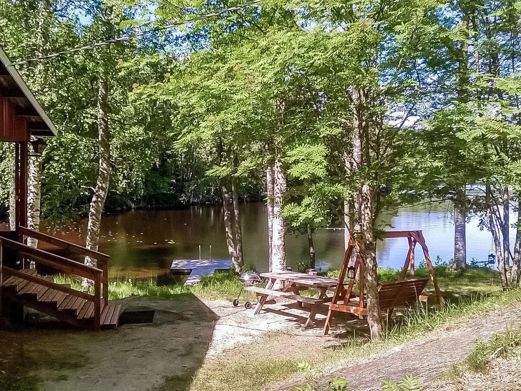 Järvenrantahuvila, jossa on laituri, piknikpöytiä ja keinuteline.