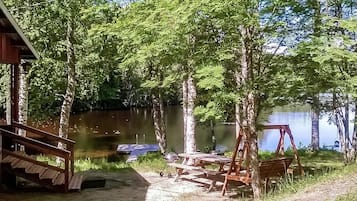 Järvenrantahuvila, jossa on laituri, piknikpöytiä ja keinuteline.