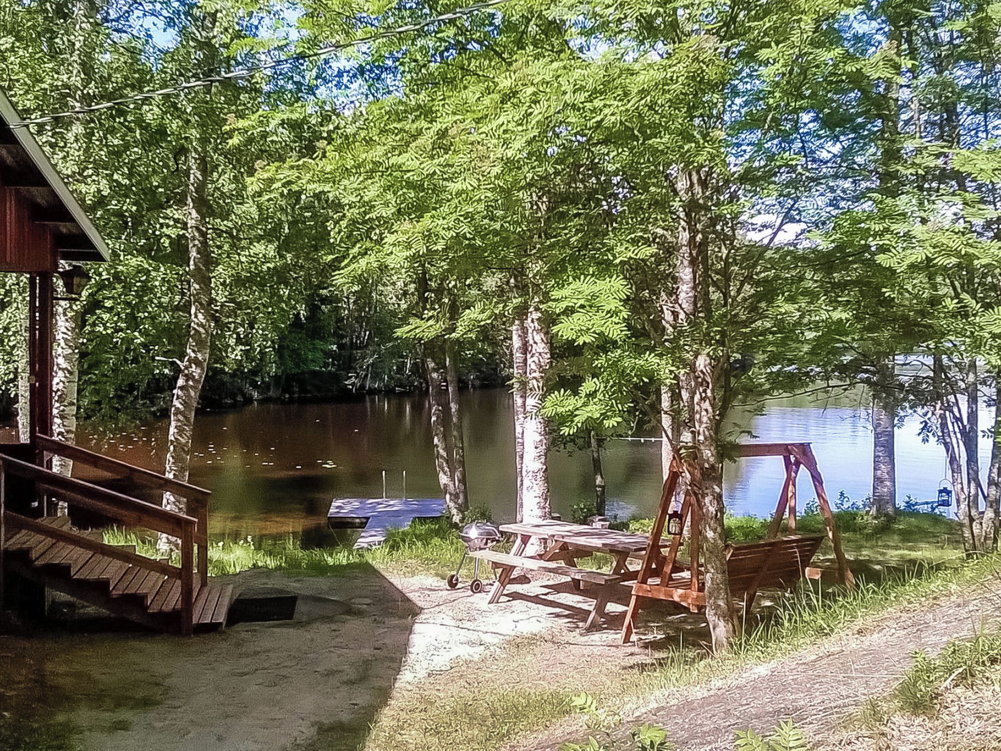 Un chalet au bord du lac, doté d’un quai, de tables de pique-nique et d’une balançoire.