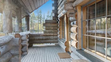 A log cabin with a wooden deck and large windows.