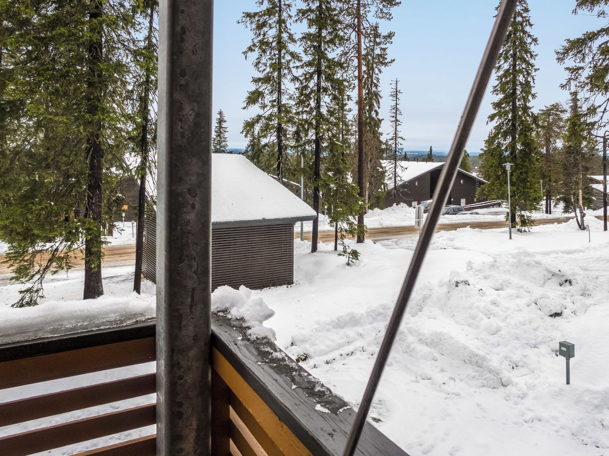 Paisatge nevós amb una cabana i arbres.