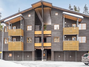 Un immeuble à plusieurs étages doté de balcons, d’un atrium central et d’un espace de stationnement.