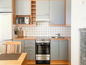 A compact kitchen with a built-in oven, a microwave, and a sink.