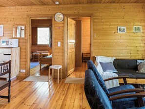 Ein Holzblockhaus-Interieur mit Wohnbereich, Küche und Essbereich.