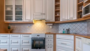 A modern kitchen with white cabinetry, a built-in oven, and a microwave.