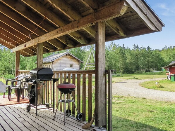 A wooden deck with a grill and outdoor furniture.