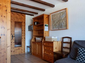Un salon chaleureux, avec des meubles en bois, une cheminée et un grand tableau abstrait accroché au mur.