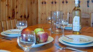 Ein Holztisch mit Tellern, Gläsern und einer Weinflasche.
