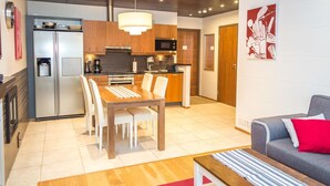 Eine moderne Küche mit einer zentralen Kochinsel, Holzschränken und einem Edelstahl-Kühlschrank.