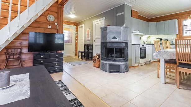Una sala de estar moderna con chimenea, comedor y cocina.