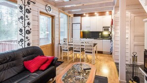 Un espacio habitable compacto con sofá, mesa de centro, zona de comedor y kitchenette.
