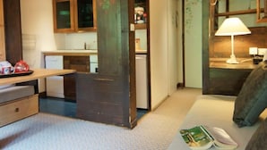 A cozy room with a wooden ceiling, a dining table, a sofa, and a lamp. - Grand Roc by Interhome (Argentière)