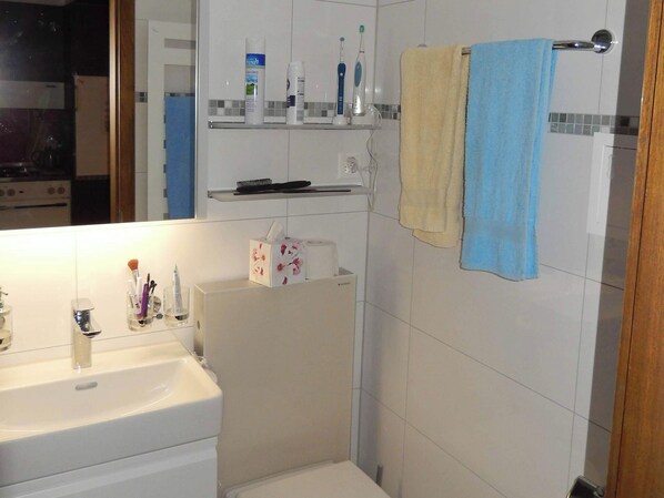 A bathroom with a sink, toothbrushes, toothpaste, and a mirror. - Sörenweg 4 Appartement/Fewo 2-Bettwohnung by Interhome (Engelberg)