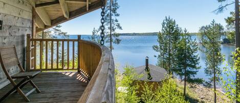 A wooden deck with a view of a lake and trees.