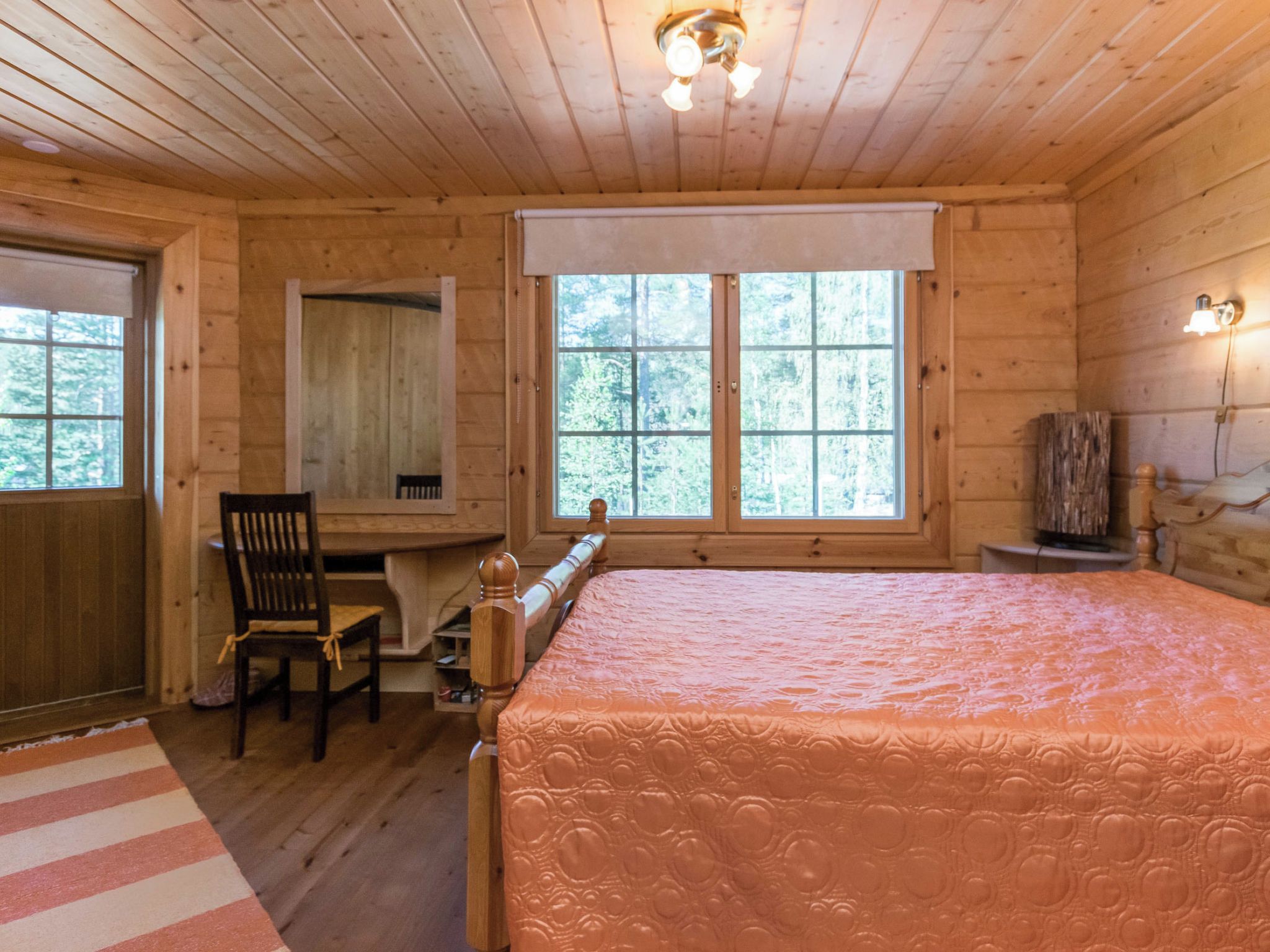 Une pièce en bois avec un lit, un bureau et une chaise.