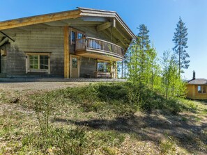 A two-story log cabin with a balcony, surrounded by a natural landscape. - Villa pyöriäinen by Interhome (Kerimäki)