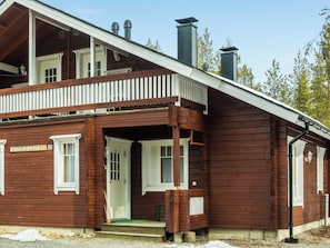 En træbygning med en veranda, en dør og et vindue.