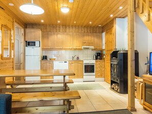 A modern kitchen with wooden cabinets, a dining table, and a built-in oven.