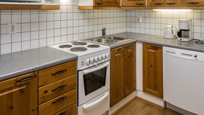 Una cocina con armarios de madera, estufa blanca, microondas y cafetera.