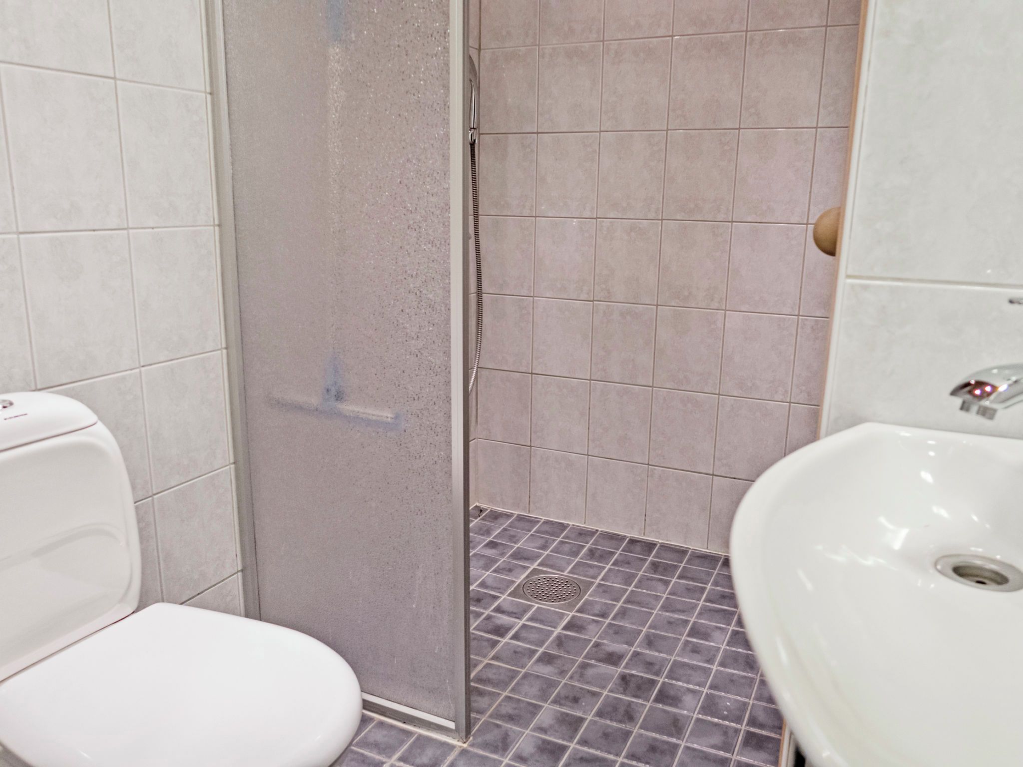A bathroom with a shower, toilet, and sink.