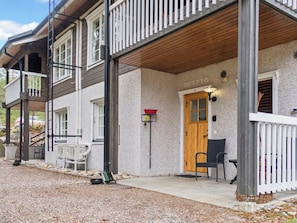 A building with a wooden porch, a door labeled 'DUETTO', and outdoor seating.