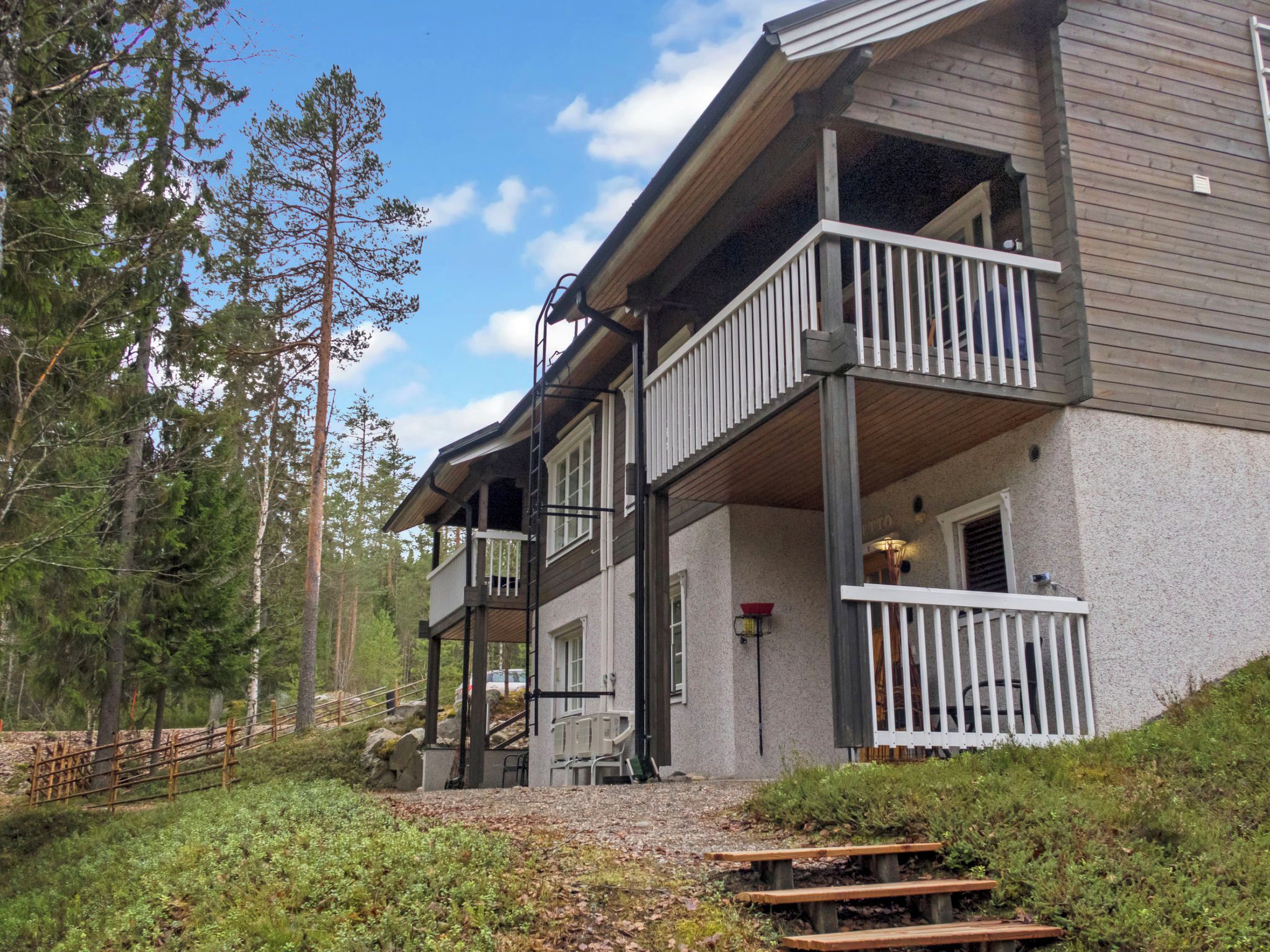 A two-story building with a balcony and a covered porch area.