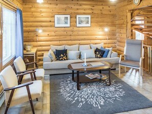 A cozy log cabin interior with a sofa, armchairs, a coffee table, and a rug. - Rinnetupa by Interhome (Kuusamo)