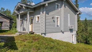 A log cabin with a porch, multiple windows, and a chimney. - Rinnetupa by Interhome (Kuusamo)