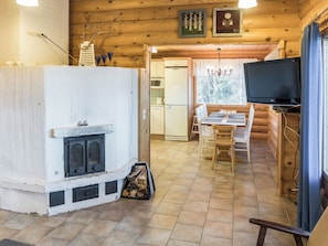 Un acogedor interior de cabaña con chimenea, comedor y televisor.