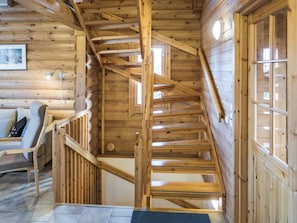 A wooden interior with a spiral staircase, a sofa, and a lamp. - Rinnetupa by Interhome (Kuusamo)