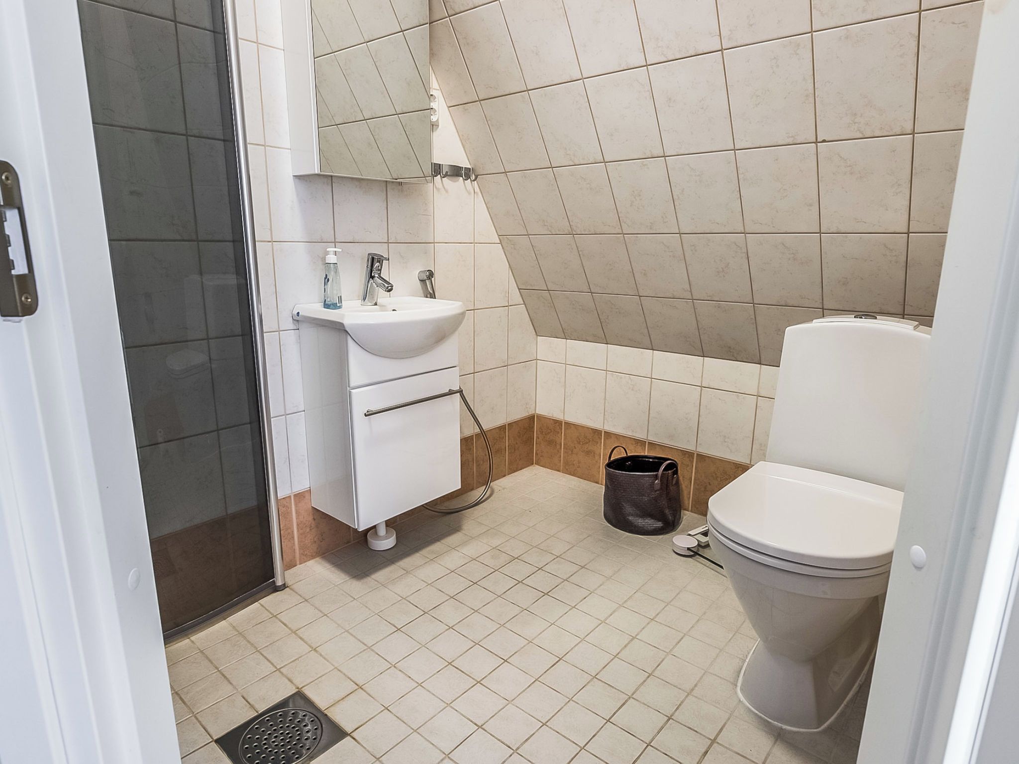 A bathroom with a white sink, mirror, and toilet.