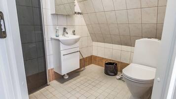 A bathroom with a white sink, mirror, and toilet.
