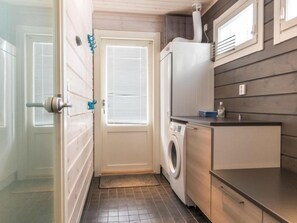 Convenient laundry facilities with a washing machine and dryer, sink, and soap dispenser.