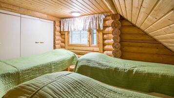 Cozy bedroom with two single beds, a window, and a wardrobe.