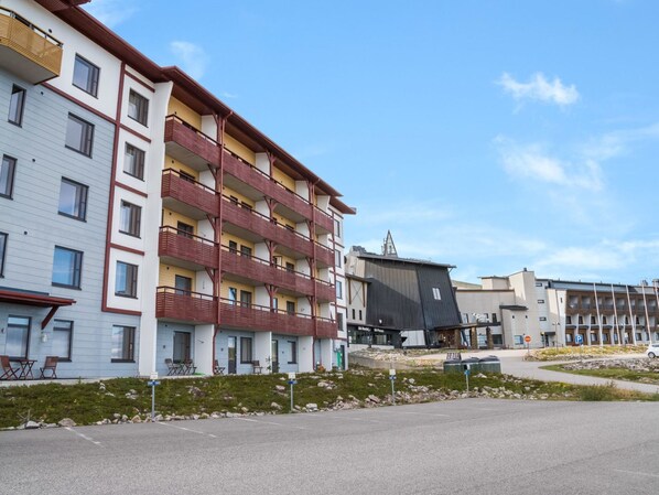 A multi-story building with balconies, a parking area, and a clear sky. - Ylläs chalets a307 by Interhome (Ylläsjärvi)