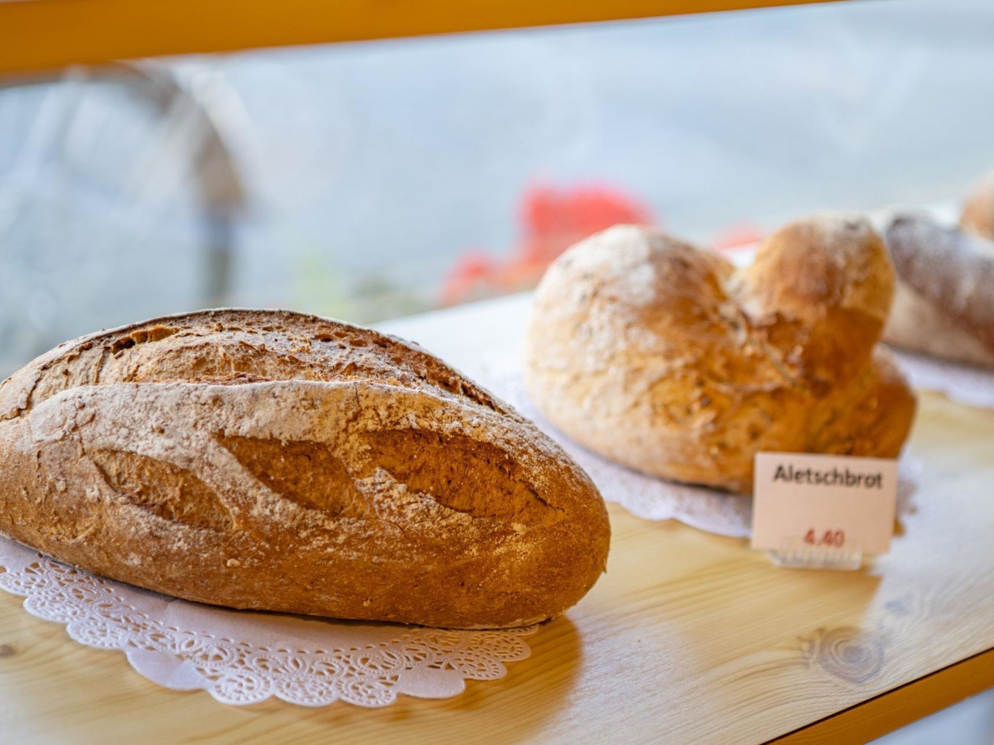 A loaf of bread and a sign with the text "Aletschbrot" and a price tag of 4.40.